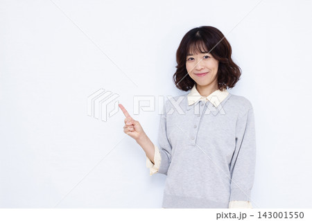 笑顔で人差し指で指す女性 143001550