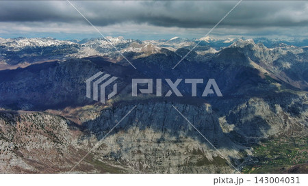 Aerial view of rocky mountain peak and green valley Aerial view of rocky mountain peak and green valley 143004031
