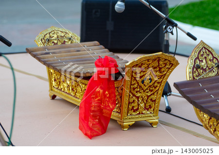 Traditional Thai Ranat Musical Instrument with Ornate Golden Decorations and Red Offering Bag 143005025