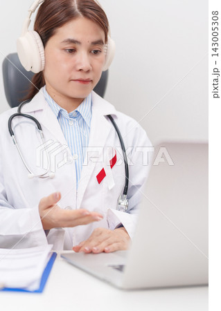 doctor using laptop for telehealth, online consultation and meeting about Burgundy and white ribbon to patient for concept of April Oral, Head and Neck Cancer Awareness month, Healthcare 143005308