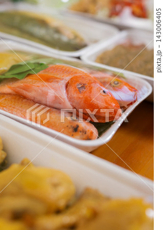 Closeup of fresh red fish in white foam trays at market counter with shallow focus and soft natural light Closeup of fresh red fish in white foam trays at market counter with shallow focus and soft natural light 143006405