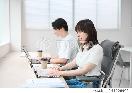 パソコンで作業をするカジュアルビジネスの男女 パソコンで作業をするカジュアルビジネスの男女 143006905
