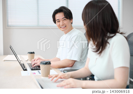 パソコンで作業をするカジュアルビジネスの男女 パソコンで作業をするカジュアルビジネスの男女 143006918