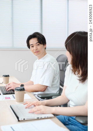 パソコンで作業をするカジュアルビジネスの男女 パソコンで作業をするカジュアルビジネスの男女 143006923