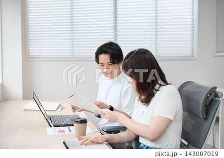 パソコンで作業をするカジュアルビジネスの男女 パソコンで作業をするカジュアルビジネスの男女 143007019