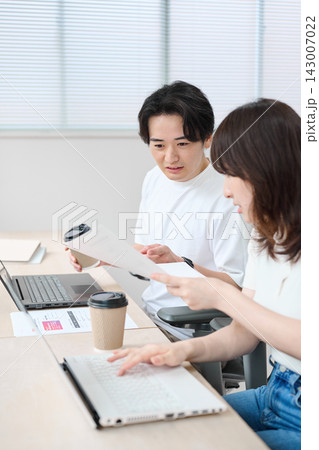 パソコンで作業をするカジュアルビジネスの男女 パソコンで作業をするカジュアルビジネスの男女 143007022