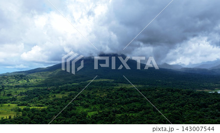 Arenal volcano peak revealing through jungle clouds 143007544
