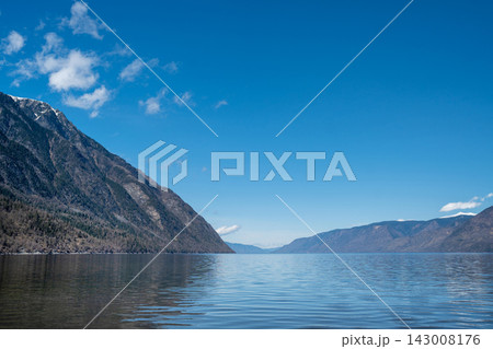 A tranquil and serene mountain lake showcasing beautiful reflections and ethereal mist 143008176