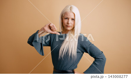 Woman expressing disapproval with thumbs down hand gesture Woman expressing disapproval with thumbs down hand gesture 143008277