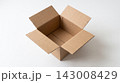An empty open delivery box made of brown corrugated cardboard sitting on a white table viewed at a 45-degree angle. 143008429
