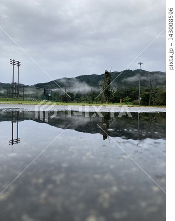 雨上がりの水たまりに映る霧の山と曇り空 雨上がりの水たまりに映る霧の山と曇り空 143008596