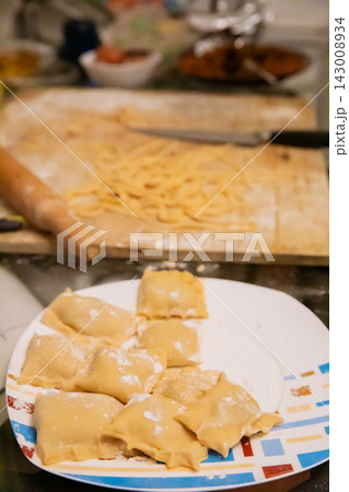 Homemade ravioli on plate with noodles in background Homemade ravioli on plate with noodles in background 143008934