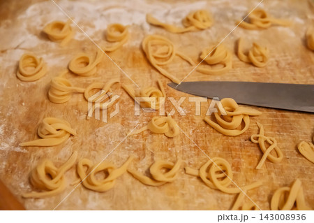 Top view of sliced pasta noodles and knife on board Top view of sliced pasta noodles and knife on board 143008936