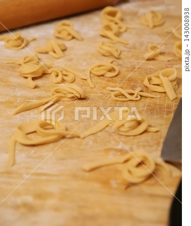 Top view of homemade noodles and knife on wooden board Top view of homemade noodles and knife on wooden board 143008938