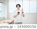 スマートフォンを持つオフィスカジュアルの若い男性 143009156