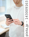 スマートフォンを持つオフィスカジュアルの若い男性 143009163