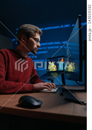 Focused data scientist writing code on keyboard in a dimly lit workspace. Focused data scientist writing code on keyboard in a dimly lit workspace. 143010192