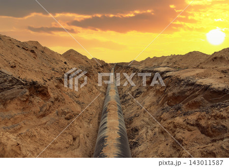 Pipeline Construction. Natural Gas Pipeline trench in ground on sunset. LNG, LPG. Oil and Gas Pipeline Construction. Natural Gas Pipeline trench in ground on sunset. LNG, LPG. Oil and Gas 143011587