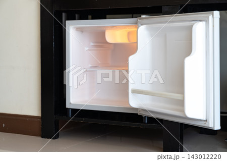 Mini refrigerator, wooden cabinet, and open wardrobe create a simple room layout focused on storage, practical furniture, and everyday accommodation use. Mini refrigerator, wooden cabinet, and open wardrobe create a simple room layout focused on storage, practical furniture, and everyday accommodation use. 143012220