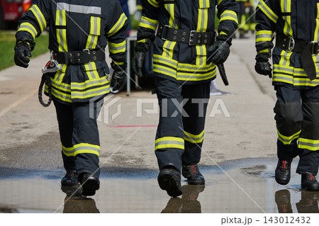 Firefighters Walking in Reflective Protective Gear and Boots During Emergency Response Training Exercise 143012432