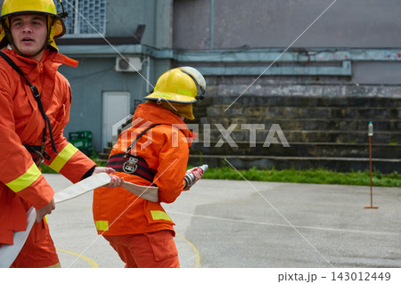 Firefighters Working Together During Outdoor Hose Drill Firefighter Training Exercise Firefighters Working Together During Outdoor Hose Drill Firefighter Training Exercise 143012449
