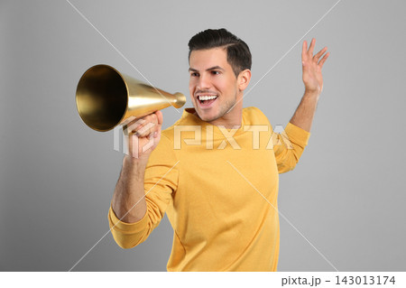 Handsome man with megaphone on grey background 143013174