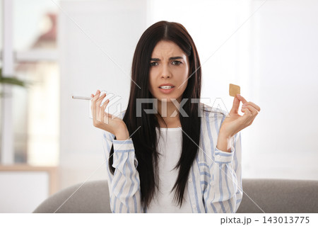 Emotional young woman with nicotine patch and cigarette at home Emotional young woman with nicotine patch and cigarette at home 143013775