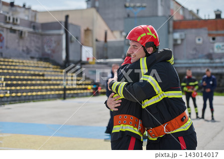 Firefighters Embracing After Training Exercise Showing Teamwork, Relief and Camaraderie in Urban Setting Firefighters Embracing After Training Exercise Showing Teamwork, Relief and Camaraderie in Urban Setting 143014017