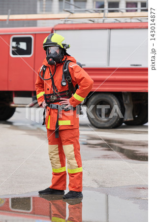 Firefighter In Full Protective Gear Standing Near Red Fire Truck With Masked Respirator 143014877