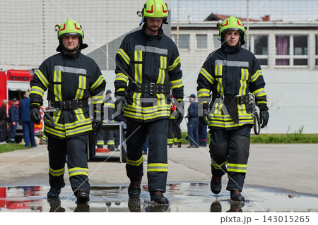 Three Firefighters Walking In Protective Gear During Emergency Drill And Fire Rescue Training 143015265