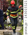 Firefighter Running With Water Hoses During Emergency Response Training In Protective Gear 143015521