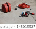 Rolled Red Fire Hoses and Multi Valve Hydrant Coupler Laid Out on Concrete at Fire Station 143015527