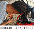 man changing wheel on a motorcycle 143016294