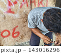 man changing wheel on a motorcycle 143016296