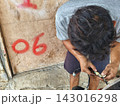 man changing wheel on a motorcycle 143016298
