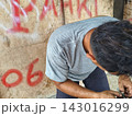 man changing wheel on a motorcycle 143016299