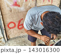 man changing wheel on a motorcycle 143016300