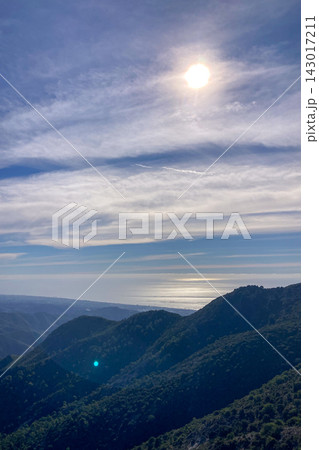 A scenic hiking trail winds through an autumn forest toward a viewpoint overlooking Sierra Blanca mountains near Ojen in Spain A scenic hiking trail winds through an autumn forest toward a viewpoint overlooking Sierra Blanca mountains near Ojen in Spain 143017211