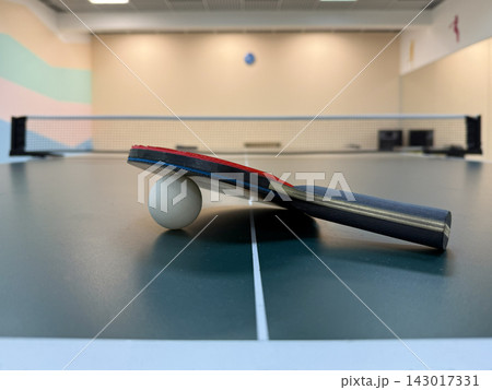 Table tennis. The racket with the sword is lying on the table. Sports ball games. Sports equipment for training, competitions, and active recreation. Table tennis. The racket with the sword is lying on the table. Sports ball games. Sports equipment for training, competitions, and active recreation. 143017331