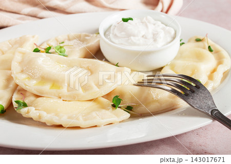 Traditional Georgian kvari dumplings, served with sour cream and herbs, close-up view, no people, Traditional Georgian kvari dumplings, served with sour cream and herbs, close-up view, no people, 143017671