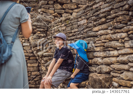 Two boys resting near ancient stone walls at Tonina Maya ruins in Chiapas Mexico with pre Hispanic history stone walls cultural heritage Mexican archaeology and exploring the ancient ruins. Two boys resting near ancient stone walls at Tonina Maya ruins in Chiapas Mexico with pre Hispanic history stone walls cultural heritage Mexican archaeology and exploring the ancient ruins. 143017761