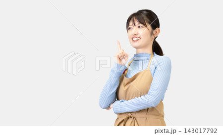 アイデアを思いつくエプロン姿の女性 143017792