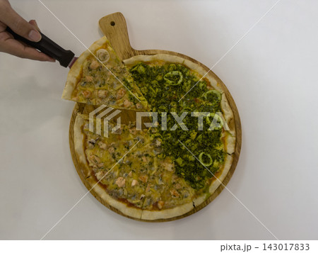 Use a server to pick up a slice of salmon pizza; the salmon and seafood-spinach pizzas can be served on a wooden tray on white floor background, food, copy space Use a server to pick up a slice of salmon pizza; the salmon and seafood-spinach pizzas can be served on a wooden tray on white floor background, food, copy space 143017833