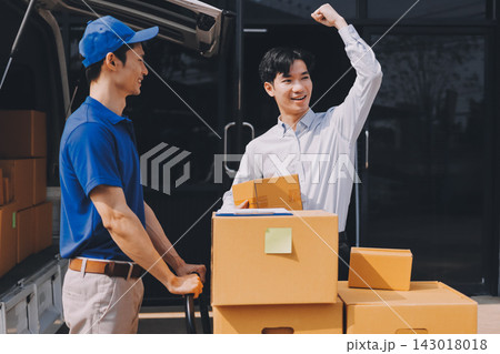 Young businessman signing a delivery receipt document on a clipboard held by a courier in a blue uniform. Young businessman signing a delivery receipt document on a clipboard held by a courier in a blue uniform. 143018018