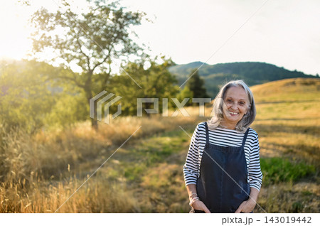 Senior woman enjoying gentle outdoor activity and connection with nature. 143019442
