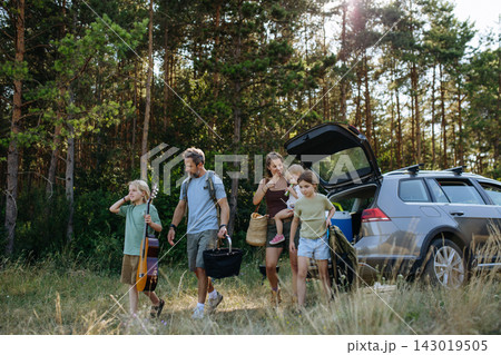 Family preparing for outdoor camping trip after traveling by car. Family preparing for outdoor camping trip after traveling by car. 143019505