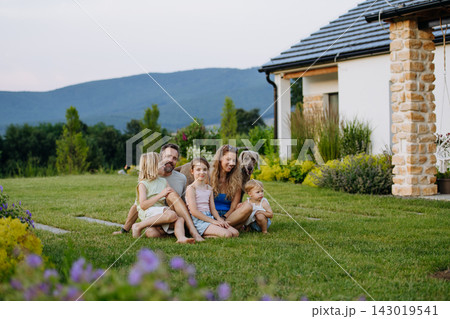 Parents and daughters enjoying late summer together outside family home. Parents and daughters enjoying late summer together outside family home. 143019541