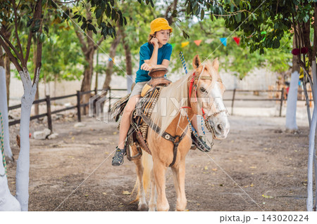 Child spends leisure time horseback riding at a farm. Outdoor recreation and family farm leisure. Child spends leisure time horseback riding at a farm. Outdoor recreation and family farm leisure. 143020224