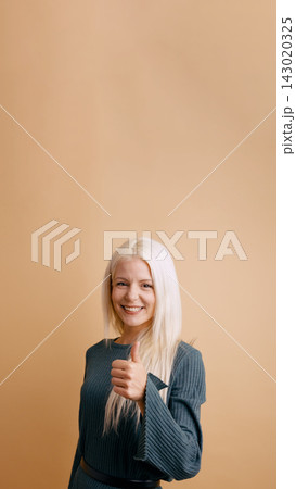 Young woman giving thumbs up approving good result 143020325