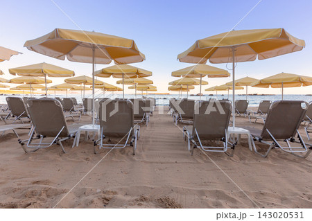 Sun Loungers and Umbrellas on Sandy Beach in Chania, Crete, Greece 143020531